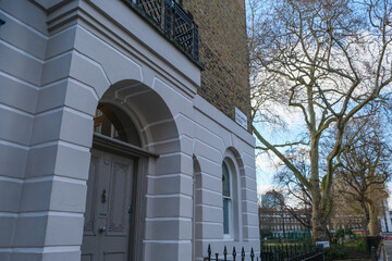 A pretty building on the corner of a street next to a park in London