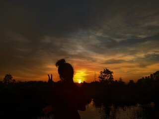 Fototapeta na wymiar silhouette of a girl on the sunset. Beautiful sunset