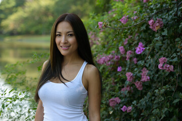 Happy beautiful Asian woman smiling at the park outdoors