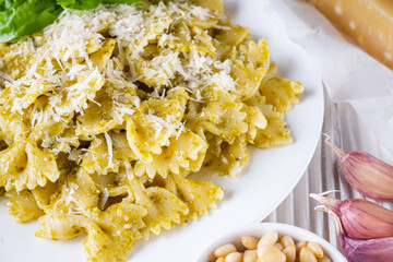 Delicious farfalle pasta with pesto sauce on wooden rustic background