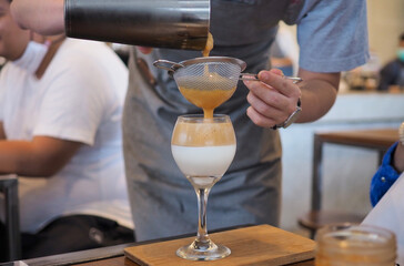 Coffee - Barista prepares whipped foam from instant coffee. Dalgona is a trendy Asian specialty.