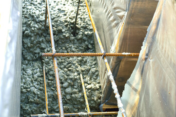 close-up - iron bonded reinforcement installed in wooden formwork