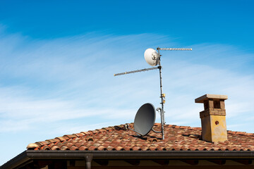 Fototapeta na wymiar Television Aerial and Satellite Dish on the House Roof