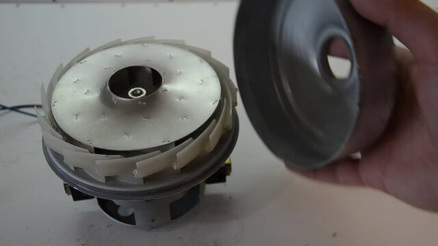 The master repairs the electric motor from a vacuum cleaner