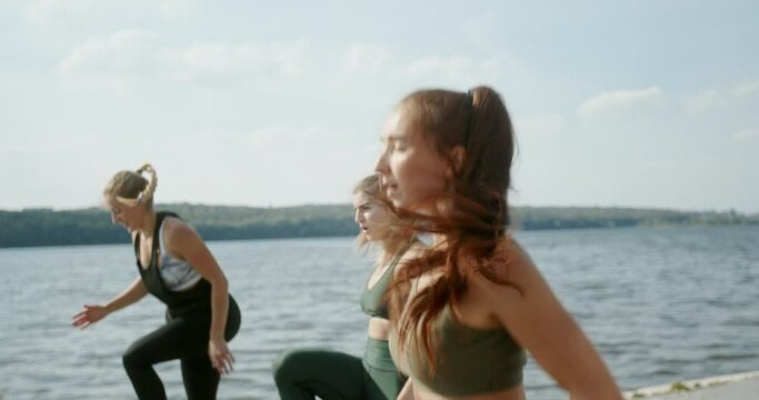fitness, training, aerobics and people concept - group of girls working out with steppers on the beach (Focus on front female body)