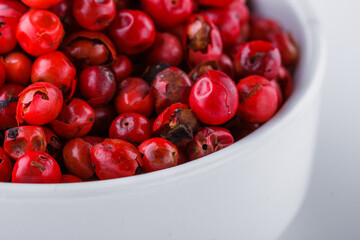 fragrant pink peppercorns on white acrylic background