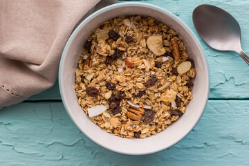 Granola in bowl with raisins,dried banana,  nuts - top view breakfast muesli background