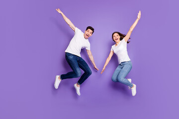 Full length photo of cheerful married couple man woman jump enjoy leisure free time rest wear...