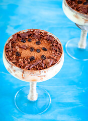 italian dessert tiramisu in an elegant cocktail glass, the concept of sweet life, luxury, delicious food