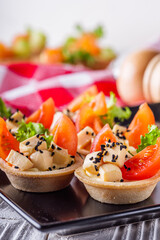 delicious snack tartlets on rustic wooden background