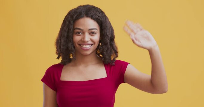 Cheerful african american girl waving hand Hello