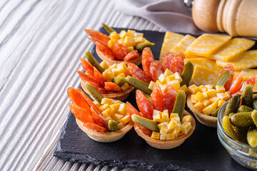 delicious snack tartlets on rustic wooden background