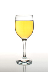 Glass of white wine with reflection on a white background