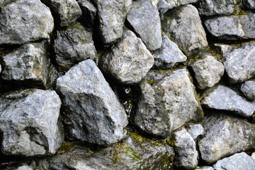Rocks wall background. Stones wall texture. Artificial waterfall made with natural grey stones. Outdoor nature.