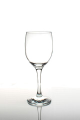 Empty wine glass with reflection on a white background