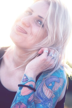 Portrait of a cute blonde woman with a sleeve tattoo