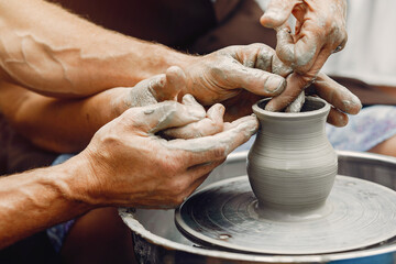 Potter make a small jug. Hands of a potter at work