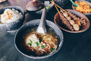 Soto Batok. Javanese beef clear soup with bean sprouts and rice; served in a traditional bowl made of coconut shell, locally known as &lsquo;batok&rsquo;. Accompanied with side dishes and condiments.