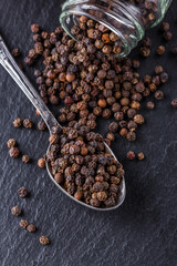 aromatic black pepper on a dark stone background