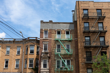 Fototapeta na wymiar Three Old Brick Residential Buildings with Fire Escapes in Astoria Queens New York