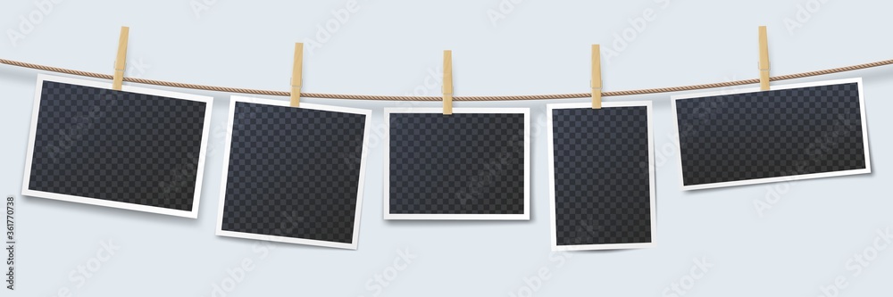 Wall mural photos hanging on rope attached with clothes pins. blank instant photo frames with transparent place