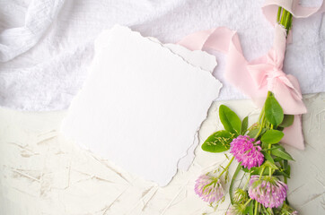 Obraz na płótnie Canvas Wedding mockup with pink flowers and delicate silk ribbons on a white background. Greeting card or wedding invitation with jagged edges. Flat lay, top