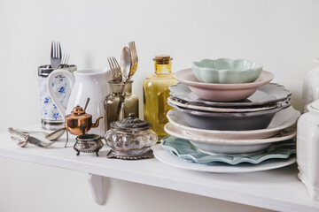 Buy old vintage romantic tableware in secondhand store concept. Pile of valuable old tableware on store shelf.