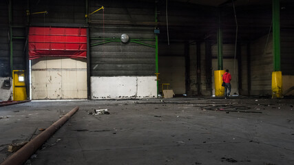 Fototapeta na wymiar un homme marchant dans une usine abandonnée. Un ancien ouvrier visitant son usine fermée. La faillite d'une entreprise