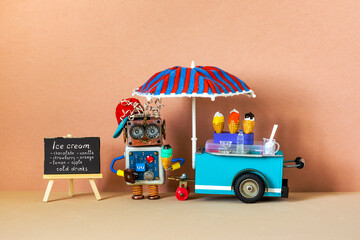 Smiling robot shopman sells cold drinks and ice cream waffle cones. A toy ice cream cart,...