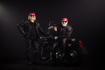 Fototapeta na wymiar Full size photo of two people retired pensioner white gray hair man woman biker driver rider sit vintage chopper wear leather jacket red bandanna sunglass isolated black color background