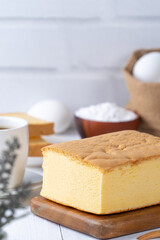 Plain classic Taiwanese traditional sponge cake (Taiwanese castella kasutera) on a wooden tray background table with ingredients, close up.