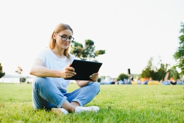 woman college student use tablet pc sit on grass