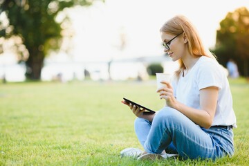 woman college student use tablet pc sit on grass