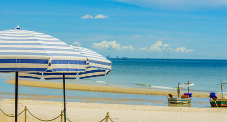 Umbrellas with sun loungers on a tropical beach.