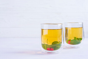 Glass cup with berry green tea and mint.