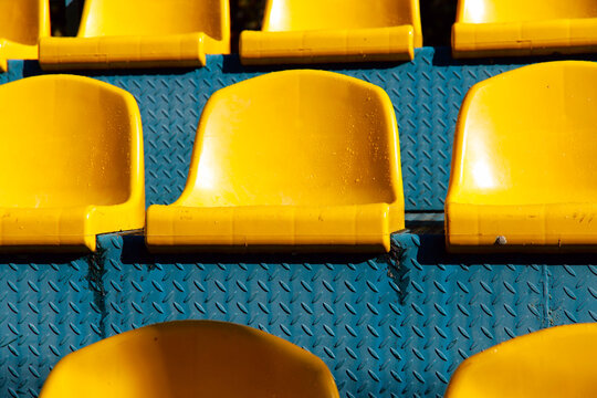 Bright yellow seats of the visual zone in the stadium close-up. A number of seats in the stadium arena. Empty arenas during quarantine. Sport concept.