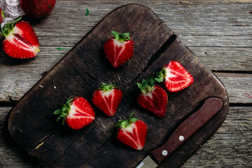 Ripe sliced ​​strawberries closeup on a wooden board