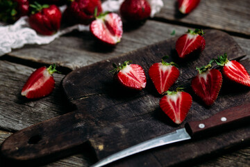 Ripe sliced ​​strawberries closeup on a wooden board