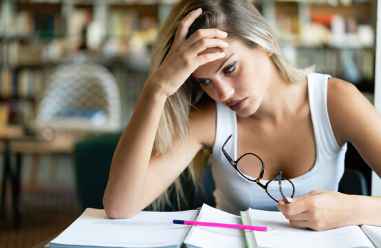 University Student Girl Bored, Frustrated And Overwhelmed By Studying Homework