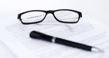 glasses and pen on a sheet of paper close-up. Contacts, business