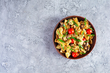 Stir fry farfalle pasta with vegetables, cauliflower and mushrooms. Top view