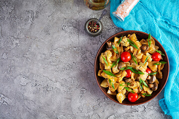 Stir fry farfalle pasta with vegetables, cauliflower and mushrooms. Top view
