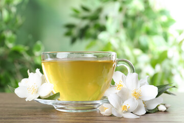 Cup of tea and fresh jasmine flowers on wooden table