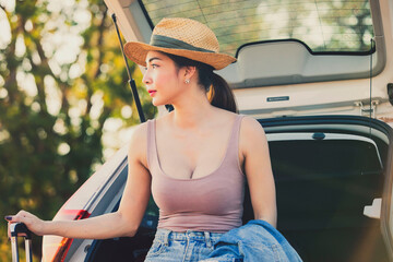 Beautiful sexy women are happy with nature.Female tourists wearing hats sitting on hatchback car,