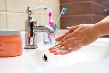 Woman washing her hands with soap close up