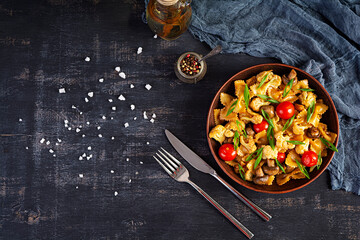 Stir fry farfalle pasta with vegetables, cauliflower and mushrooms. Top view