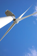 Wind turbine against beautiful blue sky, low angle view. Alternative energy source