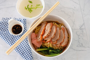 Chinese roasted duck with noodle in bowl on white background as traditional street food