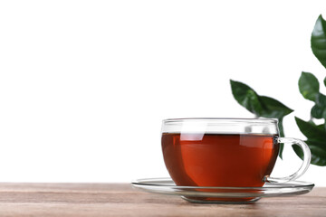 Glass cup of aromatic black tea on wooden table against white background. Space for text