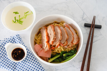 Chinese roasted duck with noodle in bowl on white background as traditional street food